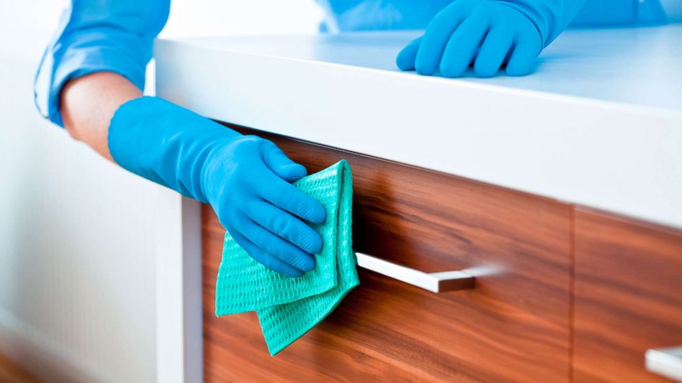 A woman cleaning kitchen cabinets in this undated stock photo.