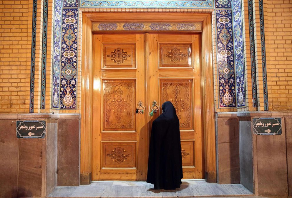 PHOTO: A woman prays outside the closed doors of the Fatima Masumeh shrine in Iran's holy city of Qom, Iran, March 16 2020. 