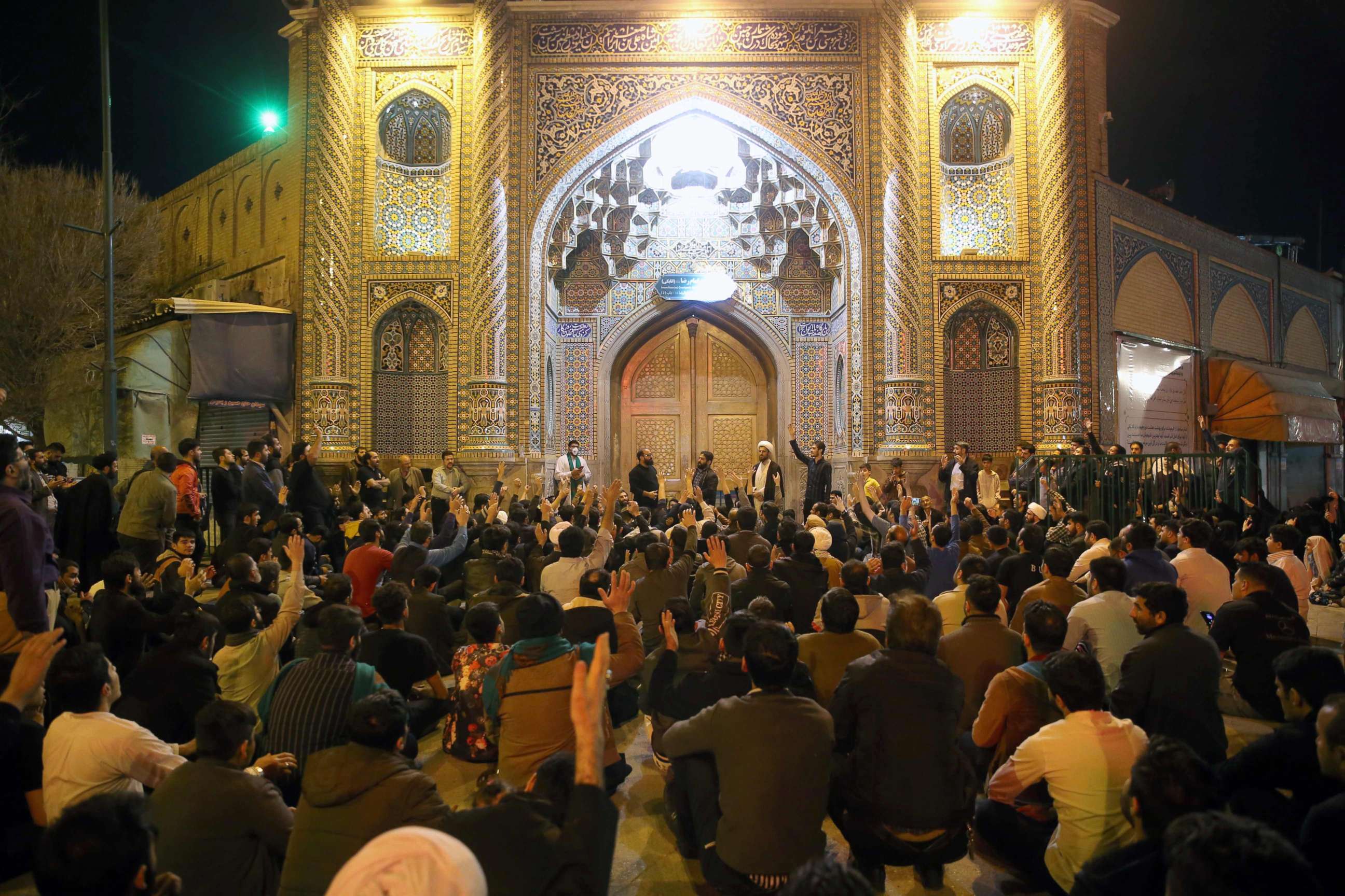 PHOTO: People gather outside the closed doors of the Fatima Masumeh shrine in Iran's holy city of Qom,Iran, March 16 2020. 