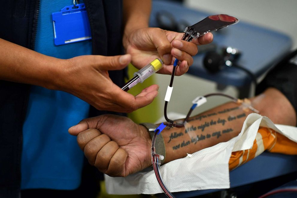 PHOTO: A plasma donor has a blood sample taken before giving convalescent plasma for COVID-19 treatment at a newly-opened plasma donor center in Twickenham, southwest London, on June 11, 2020.