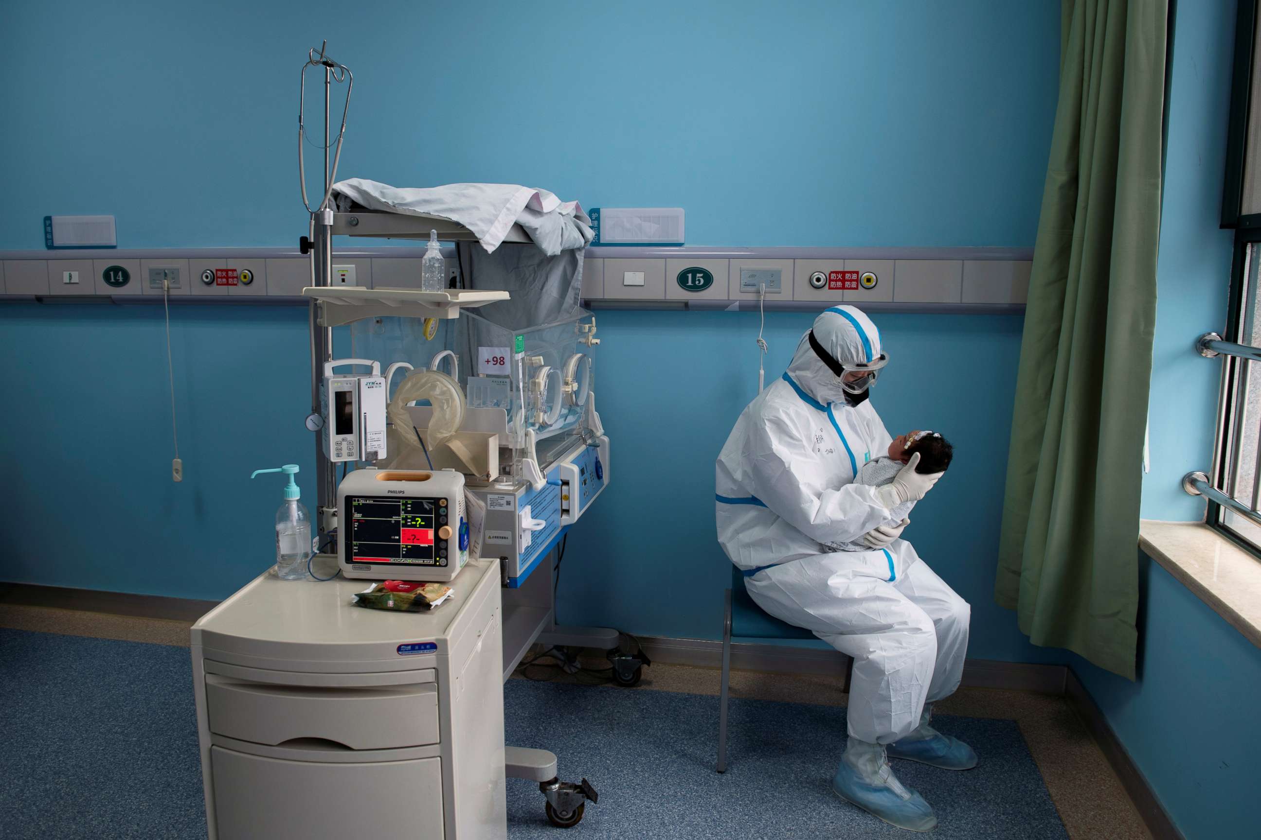 PHOTO: A nurse in protective suit attends to a baby with COVID-19 in an isolation ward of Wuhan Children's Hospital in Wuhan, China, in a photo taken on March 16, 2020.