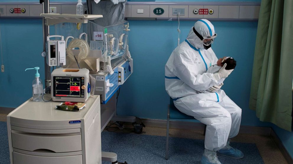 PHOTO: A nurse in protective suit attends to a baby with COVID-19 in an isolation ward of Wuhan Children's Hospital in Wuhan, China, in a photo taken on March 16, 2020.