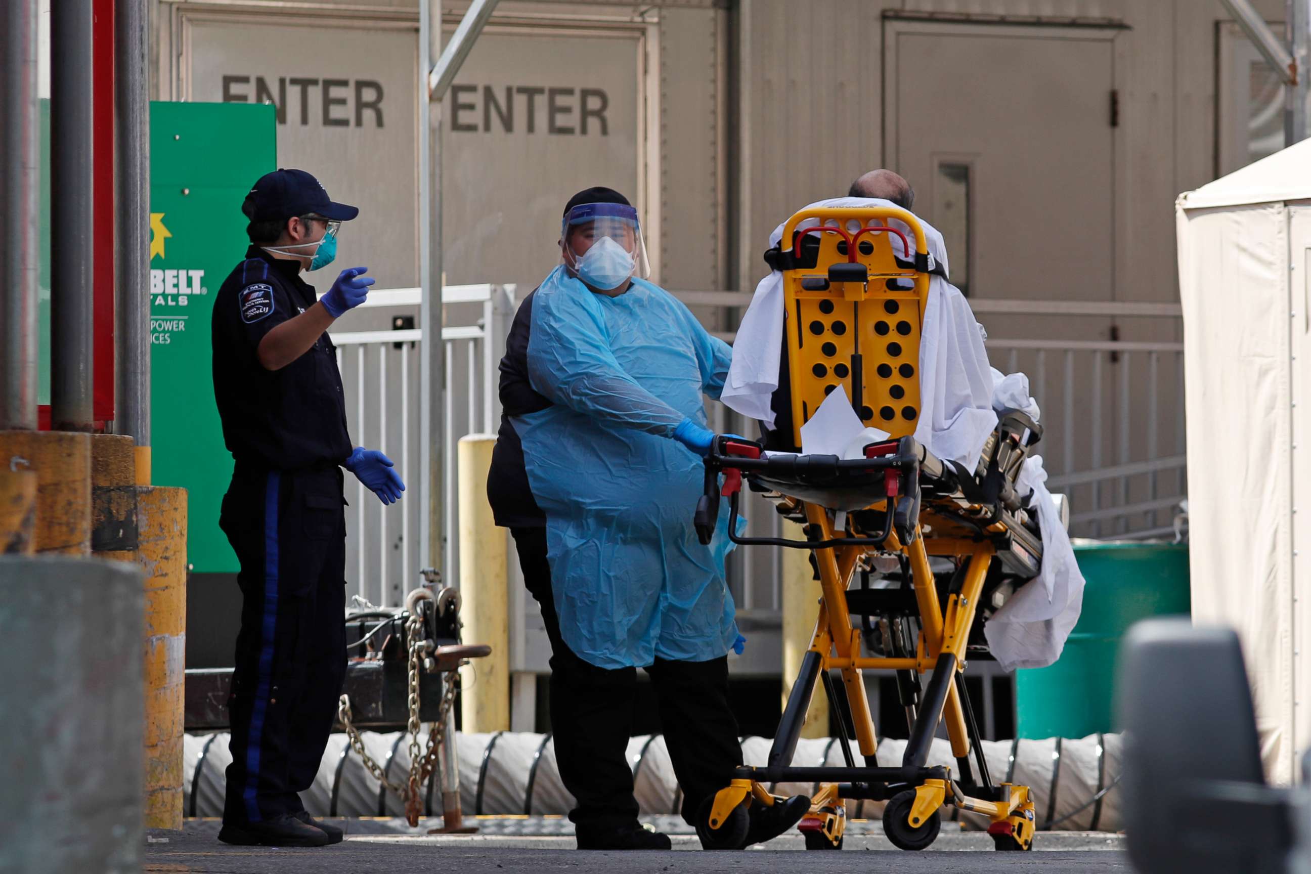 PHOTO: A patient is wheeled to a waiting ambulance outside Elmhurst Hospital Center, Tuesday, April 7, 2020, in the Queens borough of New York.