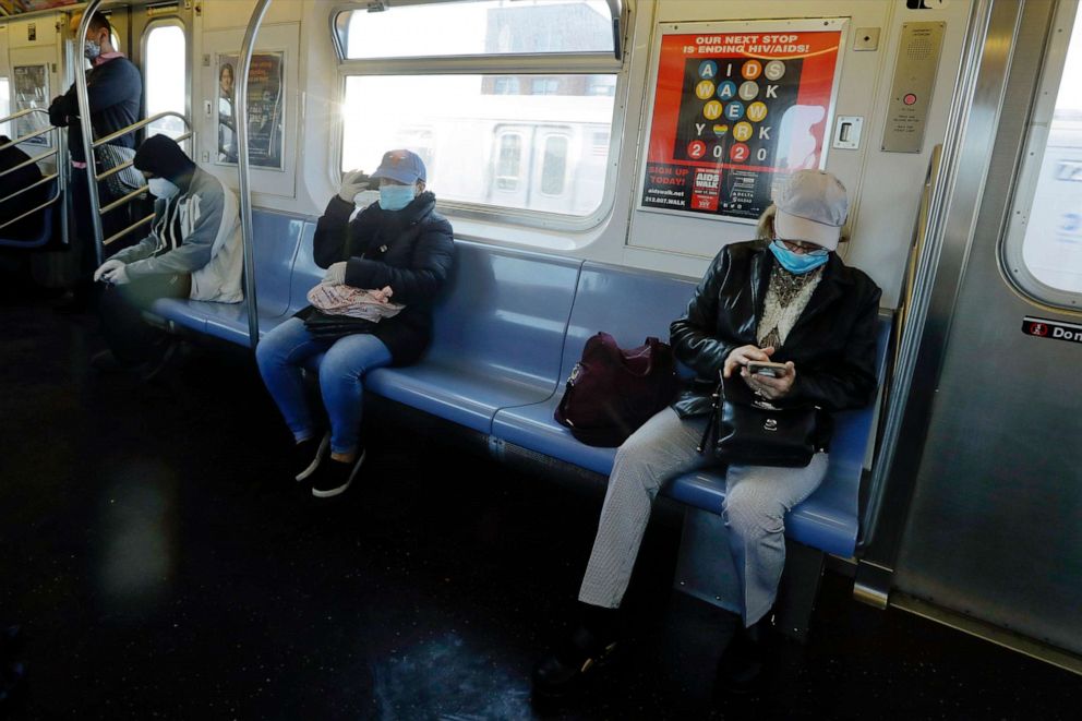 PHOTO: Patrons wear protective masks as they ride a 7 train, May 13, 2020, in the Queens borough of New York.