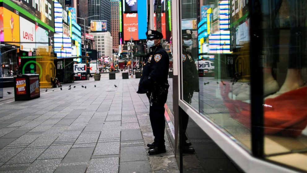 PHOTO: A New York Police officer stands guard in an almost empty Times Square during the outbreak of the coronavirus disease in New York, March 31, 2020.