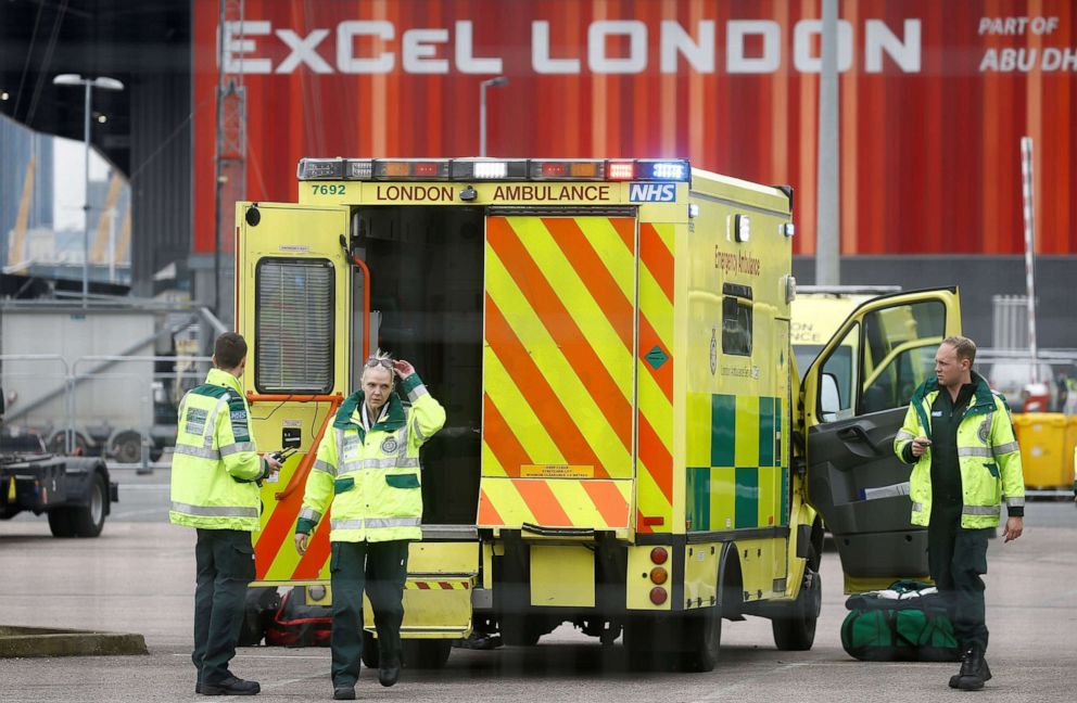 PHOTO: Paramedics and an ambulance are seen outside the Excel Centre, London while it is being prepared to become the NHS Nightingale Hospital, as the spread of the coronavirus disease continues, in London, April 1, 2020.