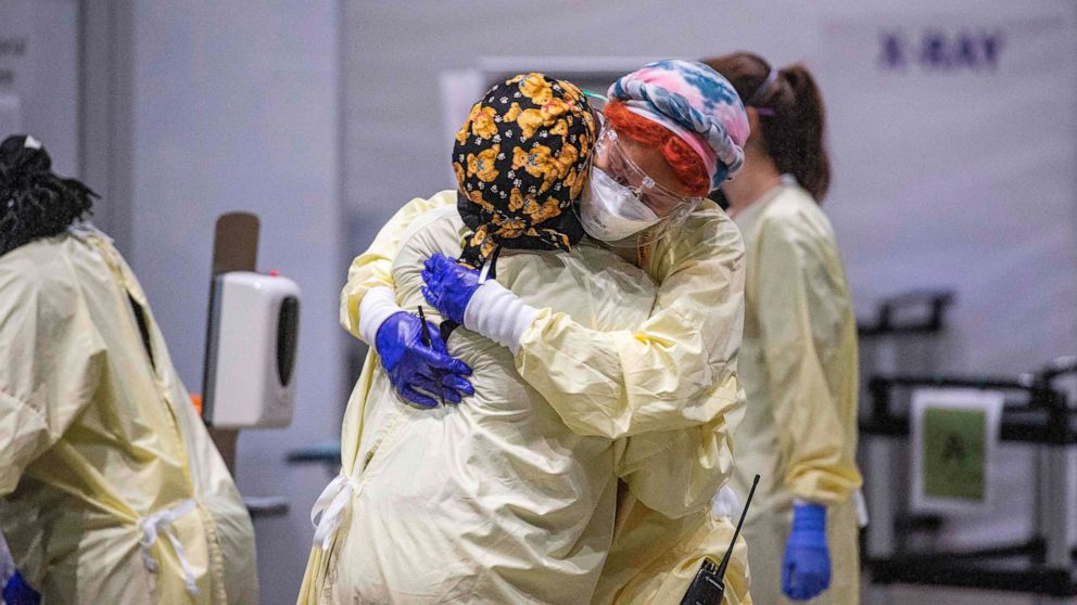 PHOTO: Medical worker Margaret Watkins embraces co-worker Shelly Burke as part of their morning therapy at the UMASS Memorial DCU Center Field Hospital in Worcester, Mass., Jan. 13, 2021.