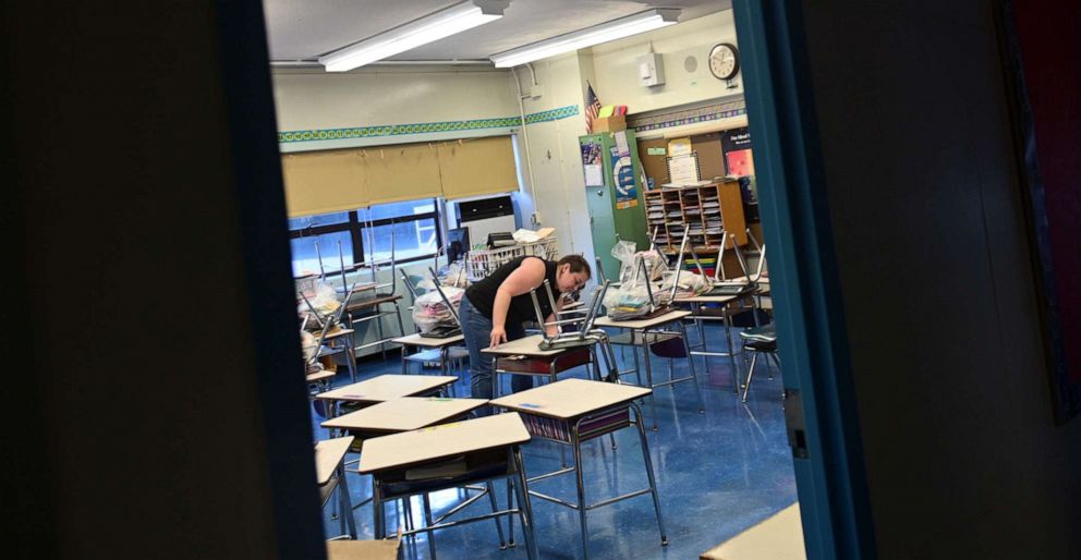 PHOTO: Holly DeMitry-Dolan, a teacher at Yung Wing School P.S. 124, moves desks and chairs in her classroom to socially distance desks for the new school year on Aug. 17, 2020, in New York.