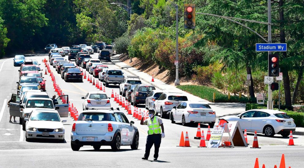 PHOTO: Traffic is directed at Dodger Stadium as people arrive for COVID-19 testing on June 30, 2020, in Los Angeles.
