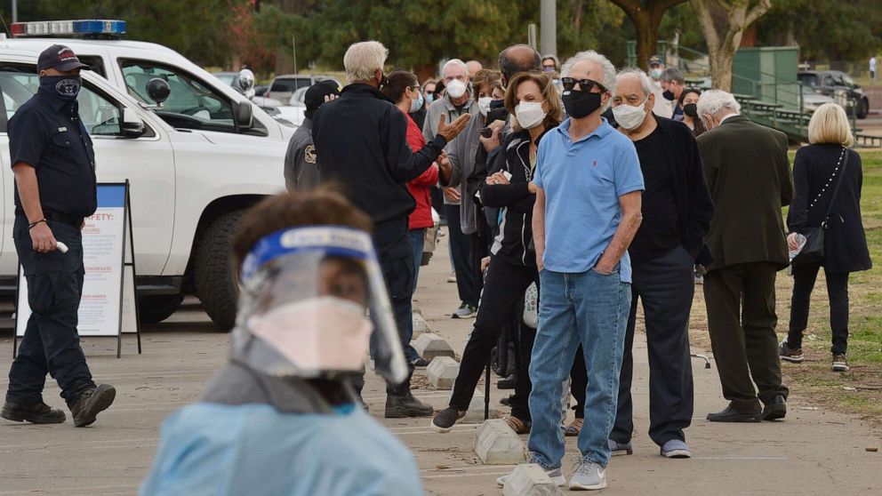 PHOTO: Residents wait in line to be inoculated with the COVID-19 vaccine at the Balboa Sports Center vaccination site in Los Angeles on Jan. 12, 2021.