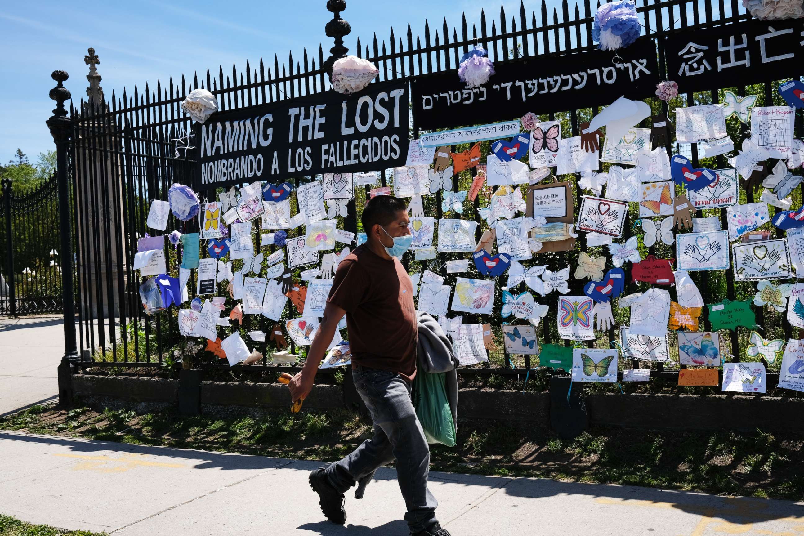 PHOTO: A man walks by a memorial for those who have died from the novel coronavirus outside Green-Wood Cemetery on May 27, 2020, in the Brooklyn borough of New York.