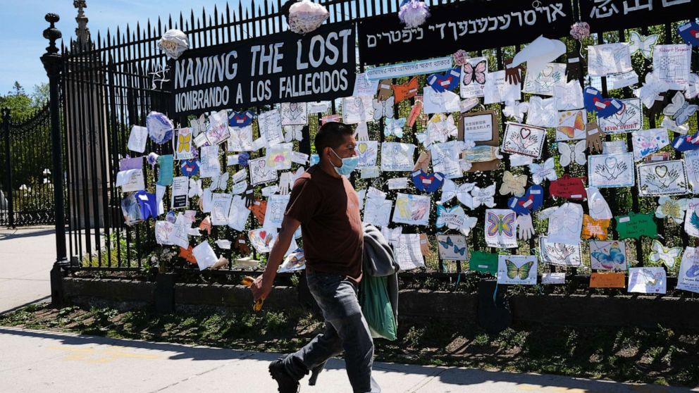 PHOTO: A man walks by a memorial for those who have died from the novel coronavirus outside Green-Wood Cemetery on May 27, 2020, in the Brooklyn borough of New York.