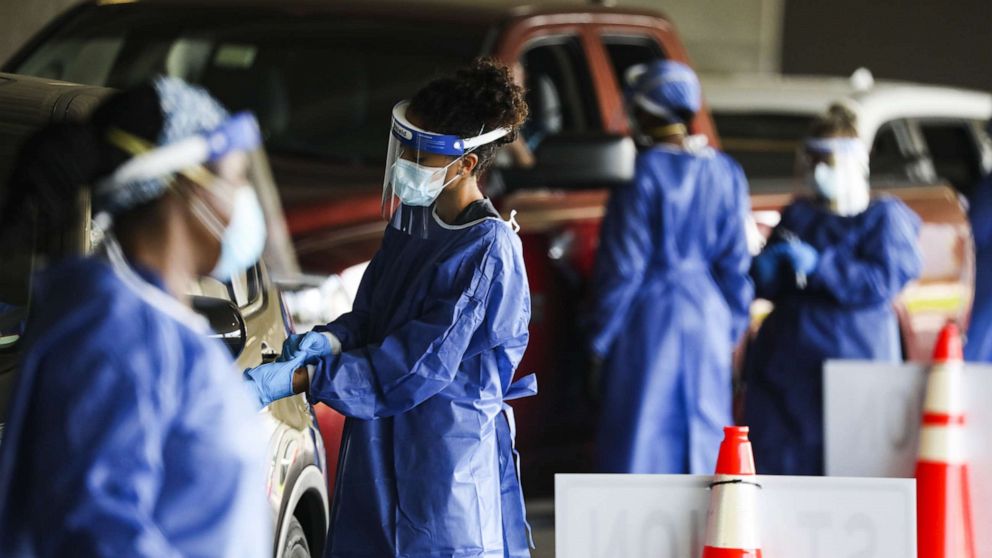 PHOTO: Healthcare workers test people at a Covid-19 testing site in the parking garage for the Mahaffey Theater in St. Petersburg, Fla., July 14, 2020.