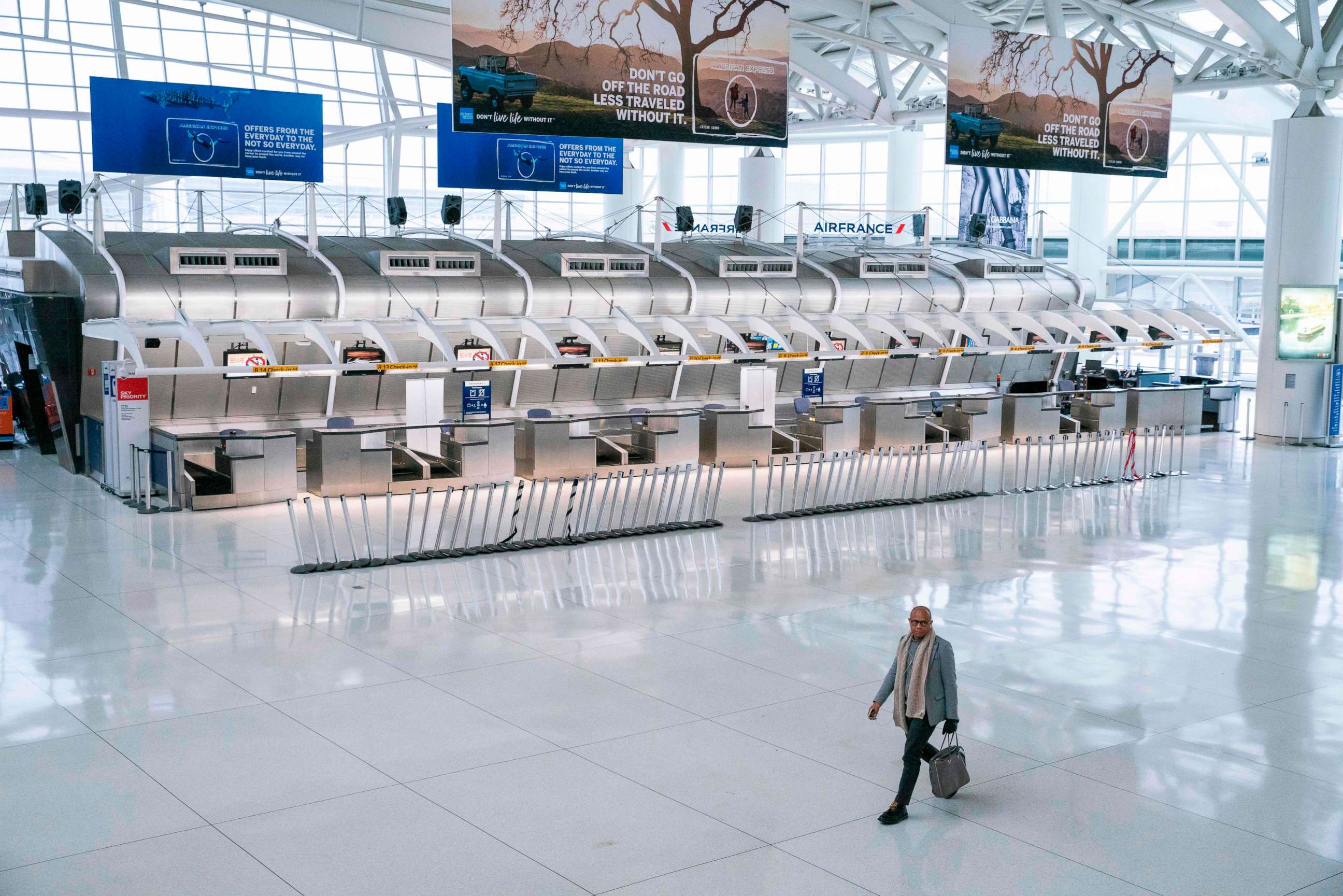 PHOTO: A man walks past the closed Air France counters at the Terminal 1 section at John F. Kennedy International Airport on March 12, 2020 in New York.