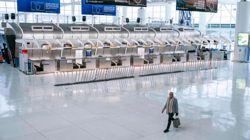 PHOTO: A man walks past the closed Air France counters at the Terminal 1 section at John F. Kennedy International Airport on March 12, 2020 in New York.