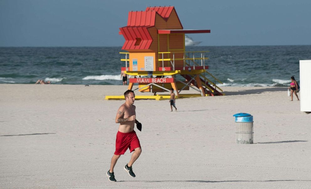 PHOTO: A man runs past a lifeguard stand in Miami Beach, Fla., July 20, 2020.