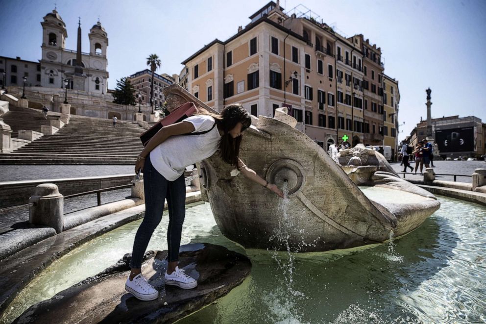 PHOTO: A woman refreshes himself at the Barcaccia fountain in Piazza di Spagna square during hot weather in Rome, Italy, July 1, 2020.