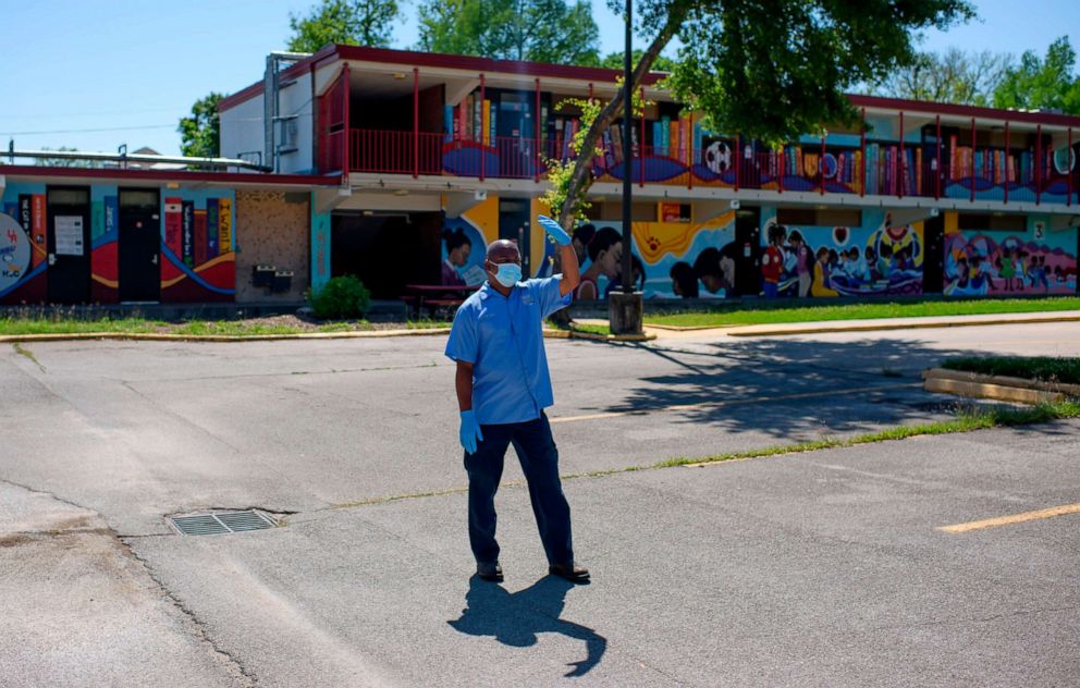 PHOTO: A volunteer waves in a car at a food distribution site at Blackshear Elementary School April 13, 2020, in Houston.