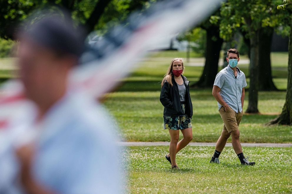 PHOTO: People walk around a protest against a mask mandate in Cleveland, July 11, 2020.