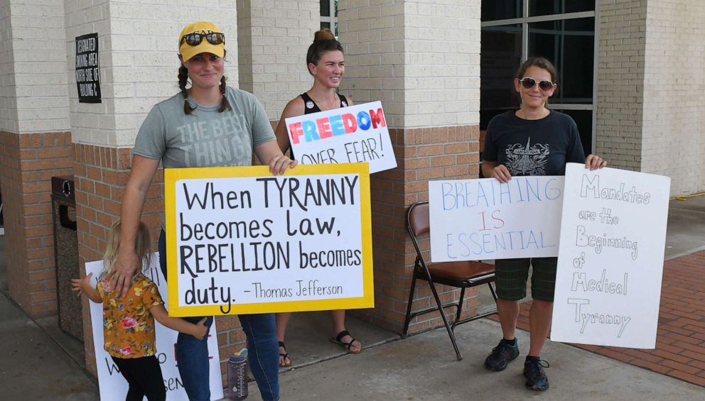 PHOTO: People protest against mandatory mask wearing outside a Brevard County Commission meeting in Viera, Fla., June 30, 2020.