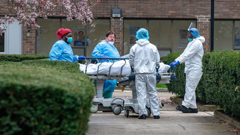 PHOTO: Kingsbrook Jewish Medical Center employees transport a deceased patient to a refrigerated truck on April 8, 2020, in the Brooklyn borough of New York.