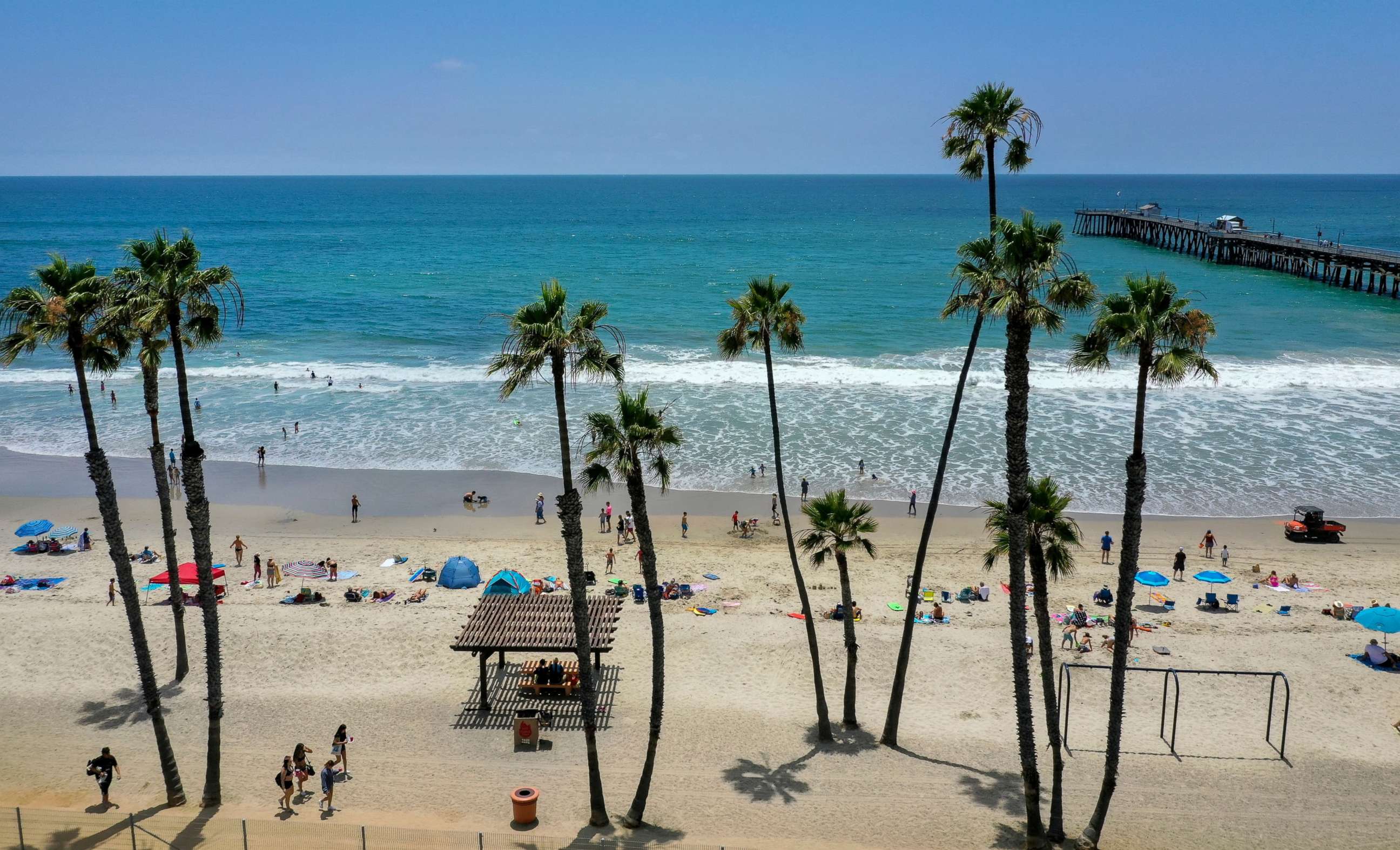 PHOTO: Beachgoers take to the water on a warm summer day at the San Clemente Pier in San Clemente, Calif., June 30, 2020.