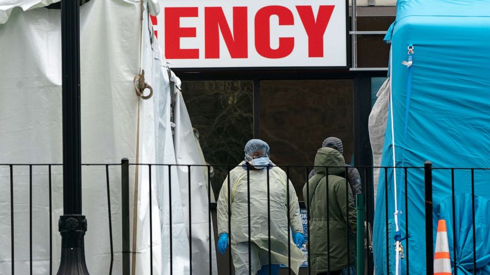 PHOTO: People wait in line to be tested for coronavirus while wearing protective gear, outside Elmhurst Hospital Center in the Queens borough of New York, March 30, 2020. 