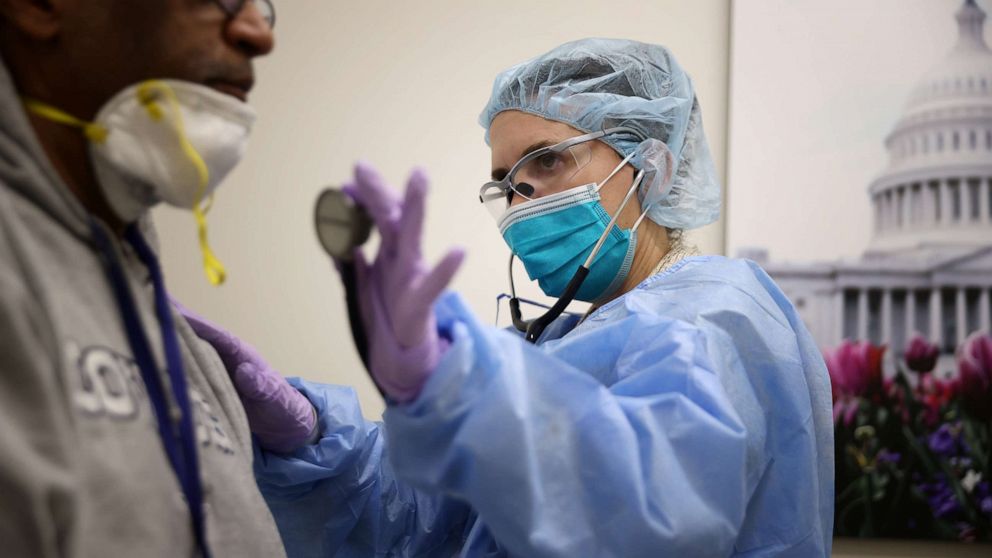 PHOTO: Nurse Practitioner Diane Alvarez examines a patient while testing him for the novel coronavirus at the Velocity Urgent Care in Woodbridge, Va., April 15, 2020.