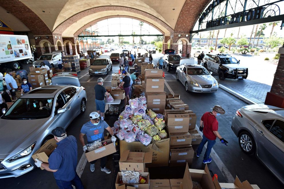 PHOTO: Volunteers give out groceries at a drive-thru Three Square Food Bank emergency food distribution site at Boulder Station Hotel & Casino in response to an increase in demand amid the coronavirus pandemic on April 29, 2020, in Las Vegas.