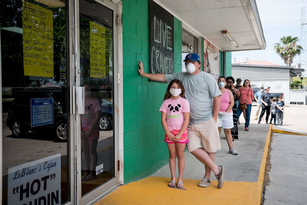 PHOTO: Customers practice social distancing while waiting to buy seafood at Schaefer Seafood in New Orleans, April 11, 2020.