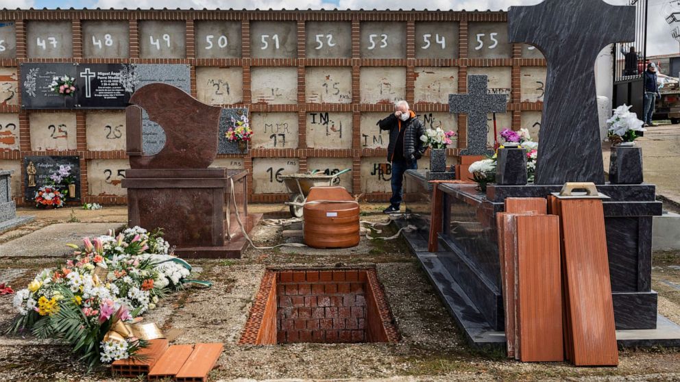 PHOTO: Julian Fernandez Mascaraque, 59, attends the burial of his mother Rosalia Mascaraque, 86, during the coronavirus outbreak in Zarza de Tajo, central Spain, Wednesday, April 1, 2020.