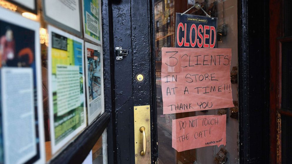 PHOTO: A sign outside a local butcher limits the number of customers in the shop, on March 20, 2020, in the Brooklyn borough of New York.