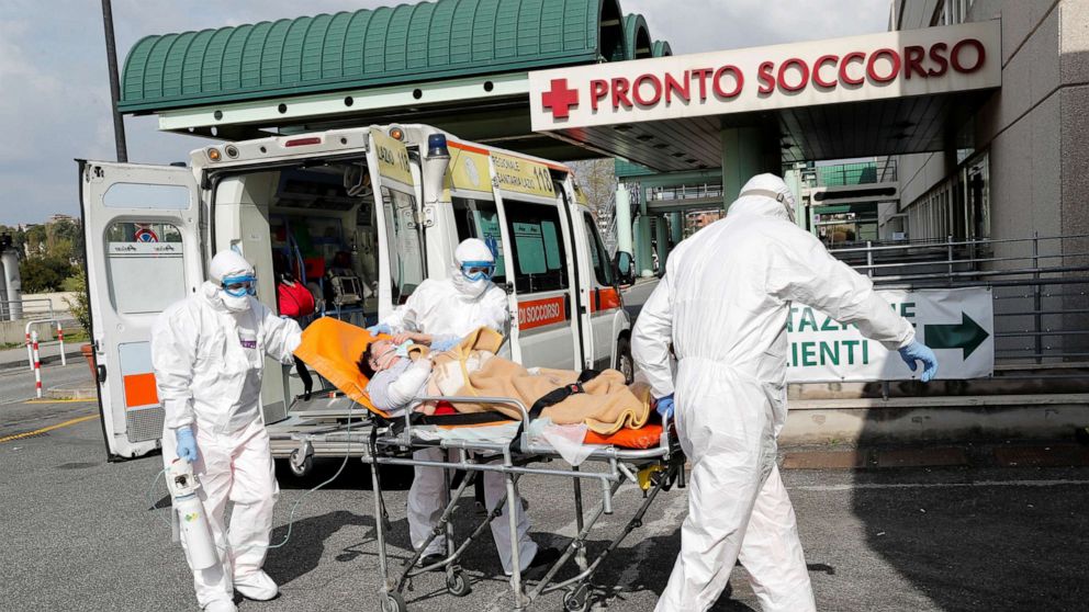 PHOTO: Medical workers in protective suits push a patient on a stretcher in front of the Policlinico Tor Vergata, where patients suffering from coronavirus are held in Rome, March 30, 2020.