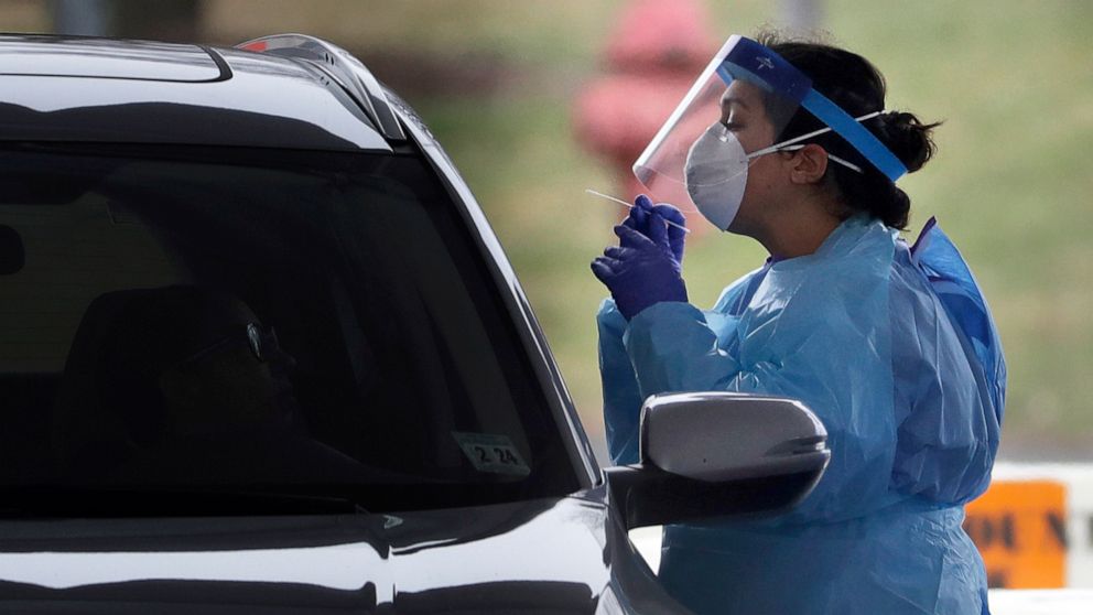 PHOTO: A medical staff member in protective gear administers a test for COVID-19 at a drive-through testing center in Paramus, N.J., March 20, 2020.