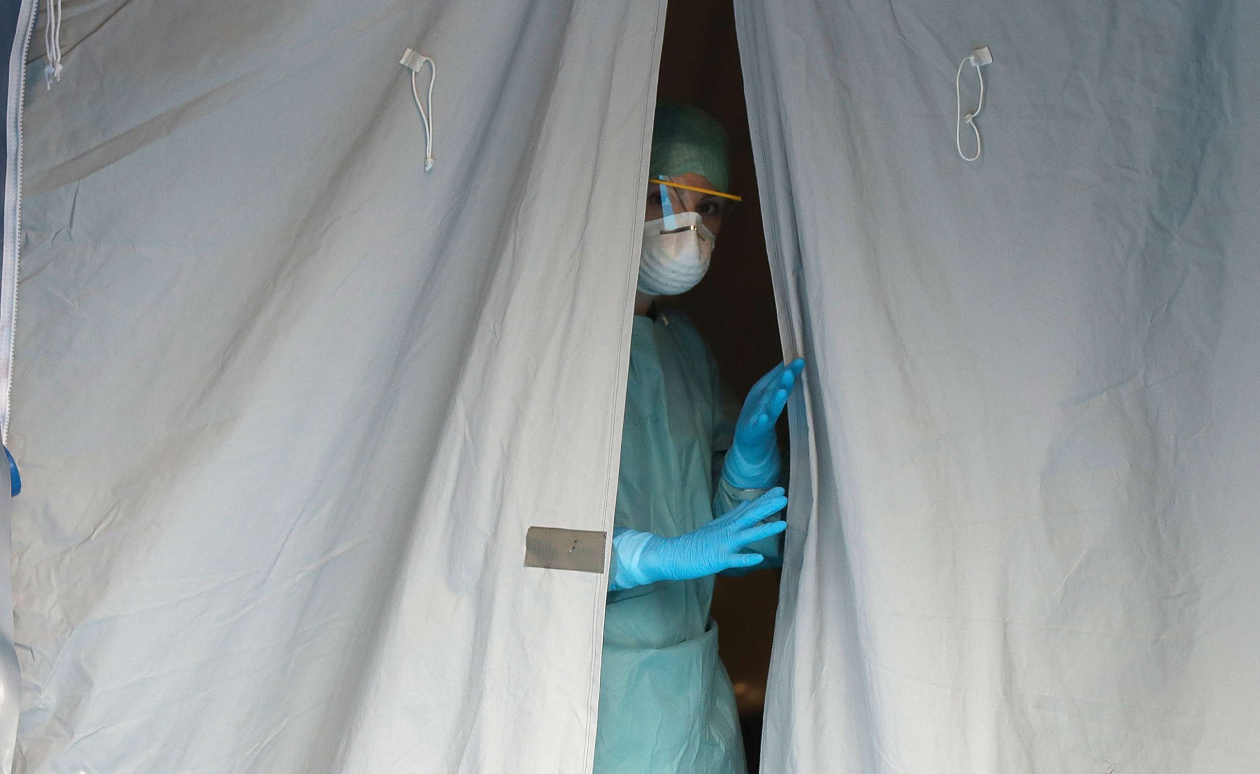 PHOTO: A medical staffer watches from a tent at one of the emergency structures that were set up to ease procedures at the Brescia hospital, northern Italy,  March 12, 2020.