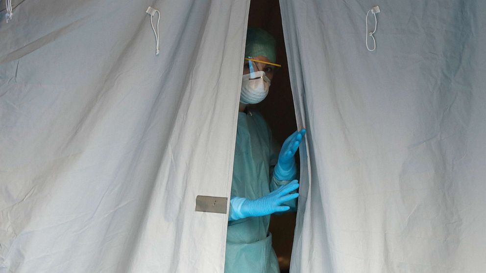 PHOTO: A medical staffer watches from a tent at one of the emergency structures that were set up to ease procedures at the Brescia hospital, northern Italy,  March 12, 2020.