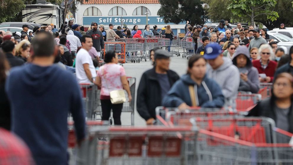 PHOTO: People wait in line to enter a Costco Wholesale store before it opens in the morning on March 12, 2020, in Glendale, Calif.