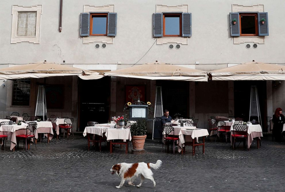 PHOTO: A dog passes in front of an empty restaurant after Italy was put on lockdown aimed at beating the coronavirus,in Rome, March 10, 2020. 