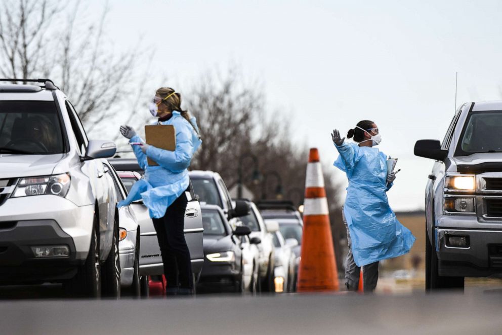 PHOTO: Healthcare workers from the Colorado Department of Public Health and Environment test people for COVID-19 at the state's first drive-up testing center on March 12, 2020, in Denver.