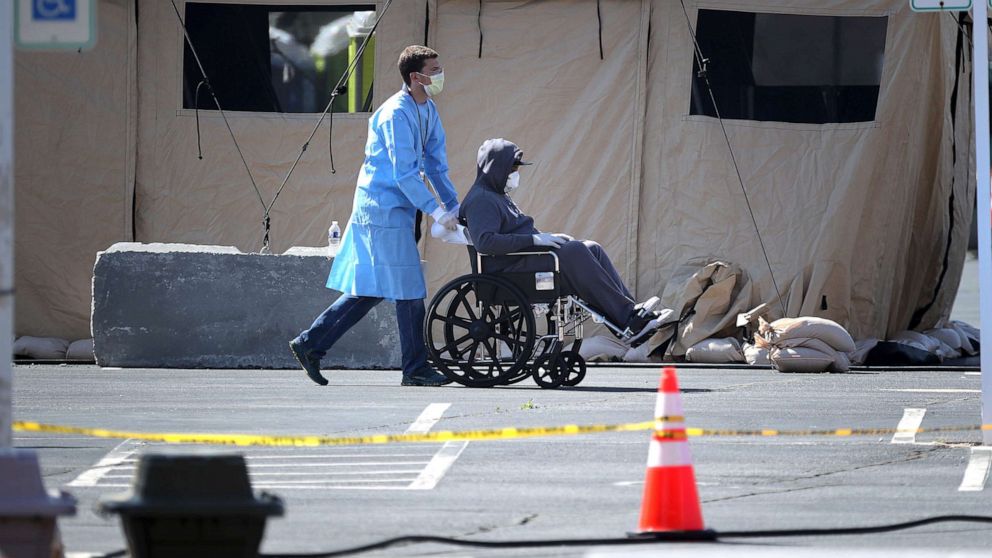 PHOTO: Healthcare professionals screen people for the coronavirus at a testing site organized by the Maryland National Guard in a parking lot at FedEx Field, March 30, 2020, in Landover, Md. 