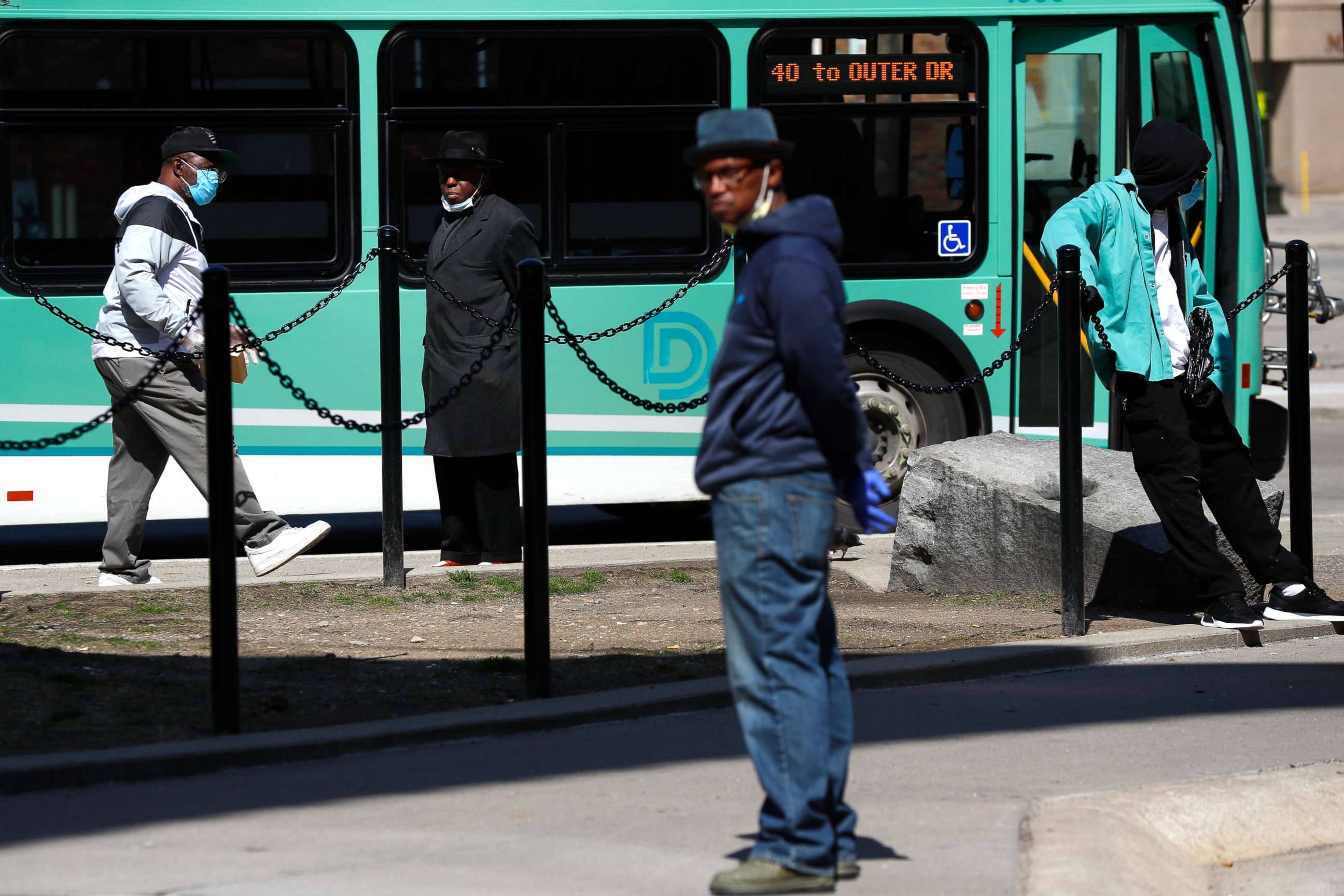 PHOTO: Riders wears protective masks during the COVID-19 outbreak waiting for a bus in Detroit, April 8, 2020.