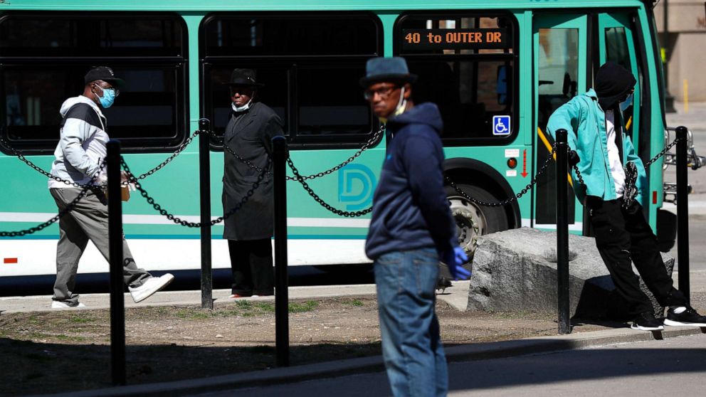 PHOTO: Riders wears protective masks during the COVID-19 outbreak waiting for a bus in Detroit, April 8, 2020.