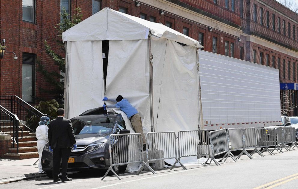 PHOTO: A hearse backs into a refrigerated truck to pick up the bodies of the deceased outside of the Brooklyn Hospital on April 1, 2020, in New York.