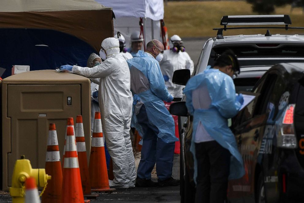 PHOTO: Healthcare workers from the Colorado Department of Public Health and Environment test people for COVID-19 at the state's first drive-up testing center on March 12, 2020, in Denver.