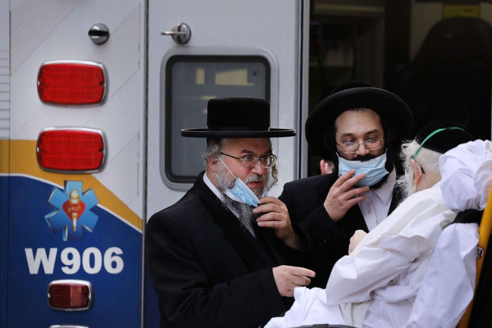 PHOTO: Hasidic men speak with an elderly patient being brought into Mount Sinai Hospital during the coronavirus pandemic on April 01, 2020, in New York.