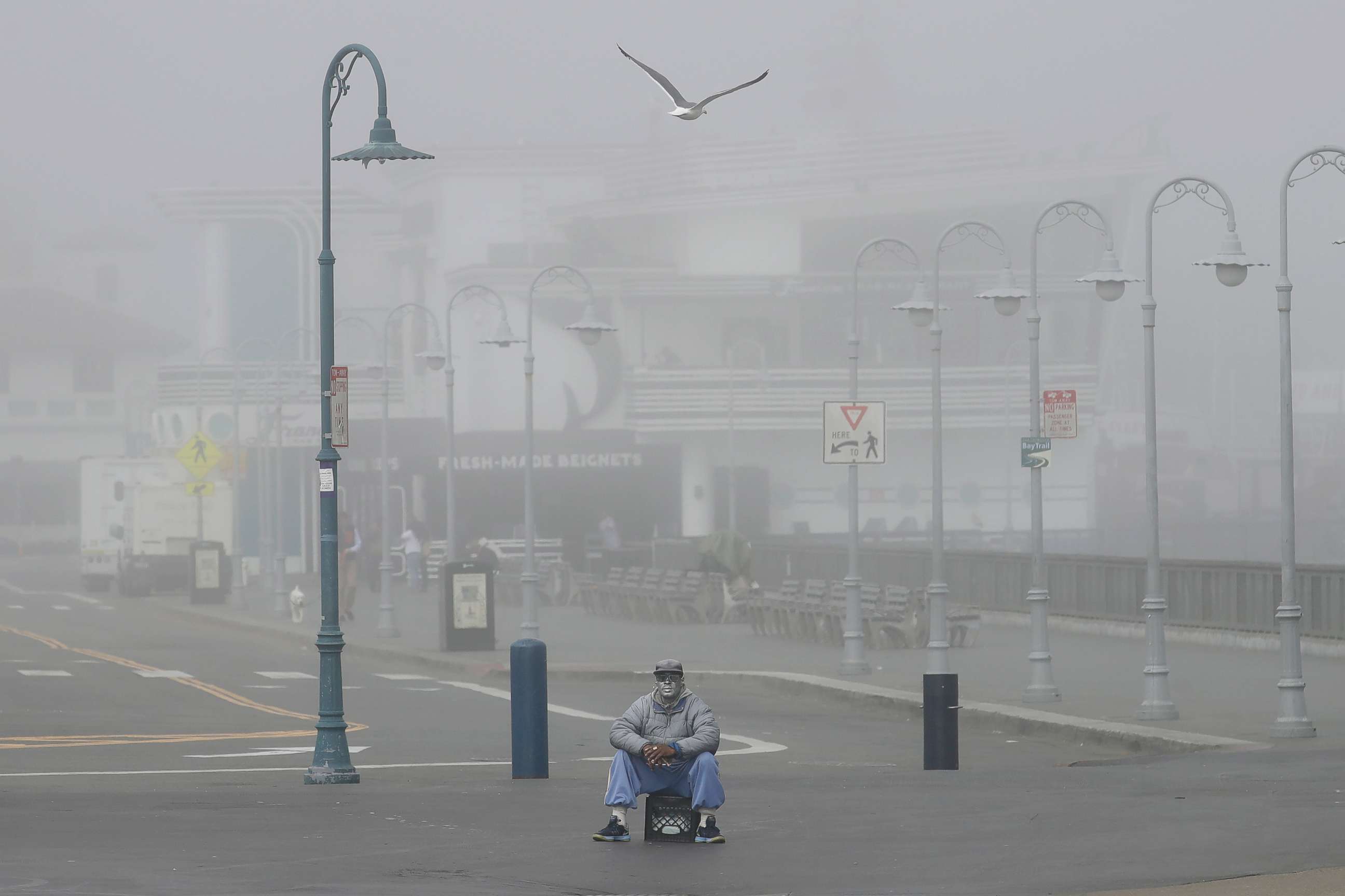 PHOTO: A street performer sits alone at Fisherman's Wharf in San Francisco, Thursday, March 12, 2020.