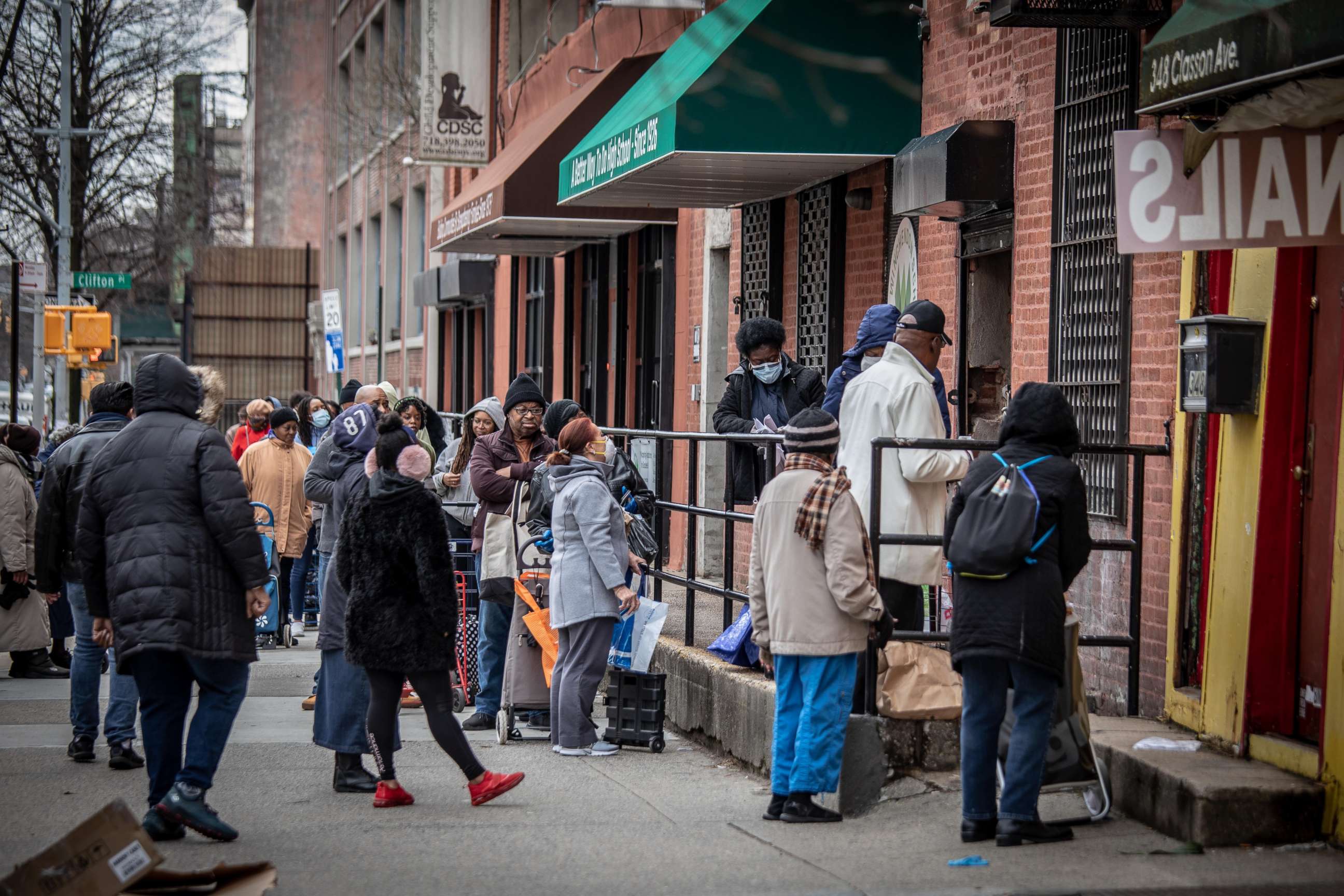 PHOTO: People stand in line outside a food pantry in the Bedford-Stuyvesant neighborhood of Brooklyn, New York, during the coronavirus pandemic, March 19, 2020.