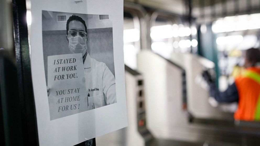 PHOTO: A flier urging customers to remain home hangs at a turnstile as an MTA employee sanitizes surfaces at a subway station with bleach solutions due to COVID-19 concerns, Friday, March 20, 2020, in New York.