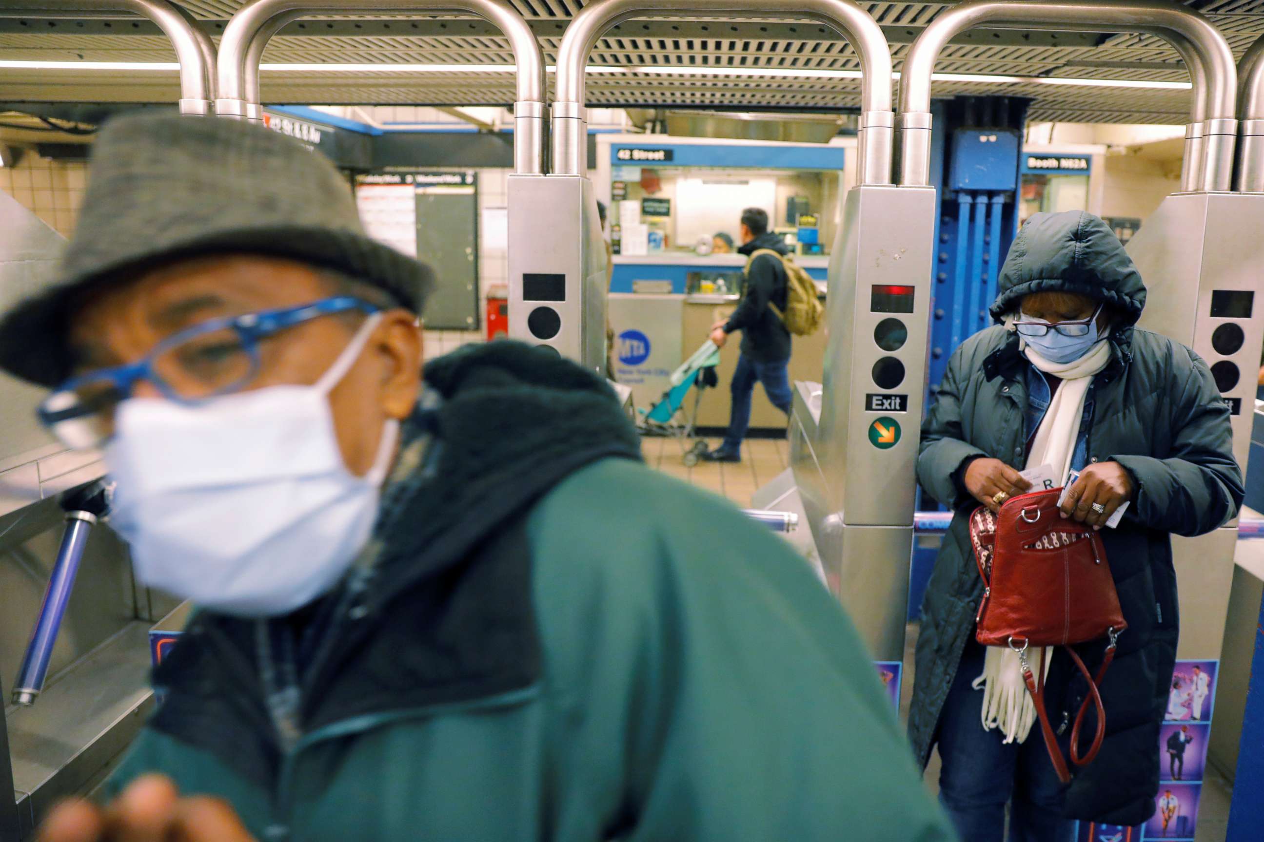 PHOTO: Commuters wearing masks enter the subway system in New York, March 12, 2020.