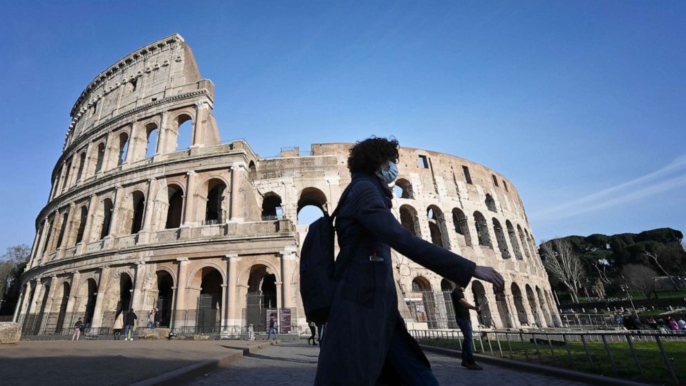 PHOTO: A person wearing a respiratory mask walks past the closed Colosseum monument in Rome, March 10, 2020, as Italy imposed unprecedented national restrictions to control the deadly coronavirus. 